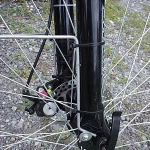 10 Guage round wire stock fender stays that are wire tied to the fork and held at the bottom with washers.